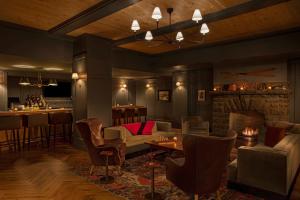 普莱西德湖Grand Adirondack Hotel, Lake Placid, a Tribute Portfolio Hotel的带沙发和椅子的客厅以及酒吧。