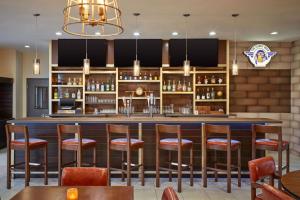 休斯顿Four Points by Sheraton Houston Intercontinental Airport的餐厅的酒吧,带木凳