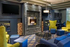 威利斯顿威利斯顿福朋喜来登酒店的客厅设有壁炉和蓝色家具。
