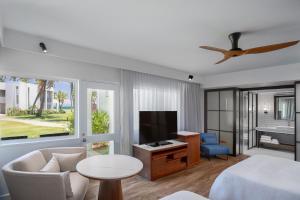 丹娜努Sheraton Fiji Golf & Beach Resort的客厅配有床和平面电视