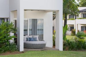 丹娜努Sheraton Fiji Golf & Beach Resort的白色房子,在庭院里配有沙发