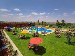 TunisTunis Pyramids Hotel - فندق اهرامات تونس的公园的顶部景色,设有桌子和遮阳伞