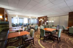 科里奥波利斯匹兹堡机场喜来登酒店的用餐室设有桌椅和窗户。