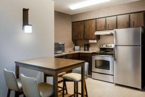 路易维尔Residence Inn by Marriott Boulder Broomfield的厨房配有桌子和不锈钢冰箱。