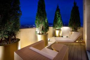 首尔首尔江南雅乐轩酒店的屋顶庭院在晚上提供椅子和树木