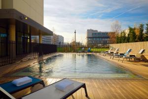 布拉尼亚克Residence Inn by Marriott Toulouse-Blagnac的大楼内一个带躺椅的游泳池