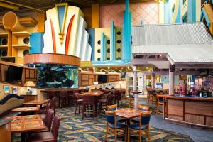 可可比奇可可海滩福朋喜来登酒店的餐厅设有桌椅,墙上设有冲浪板。