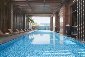 台东台东桂田喜来登酒店的一座带椅子的建筑内的游泳池