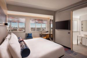马德里Aloft Madrid Gran Via的配有一张床和一台平面电视的酒店客房