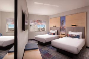 马德里Aloft Madrid Gran Via的酒店客房,设有两张床和镜子