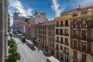马德里Aloft Madrid Gran Via的一条城市街道,有建筑和公共汽车