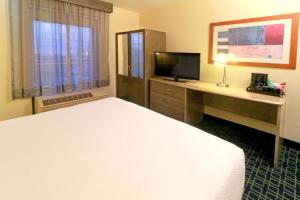 蒙特雷Wyndham Garden Monterrey Aeropuerto的酒店客房配有一张床和一张书桌及一台电视