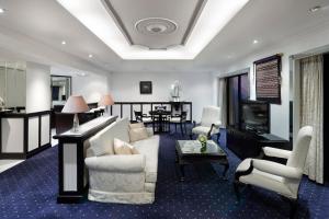雅加达雅加达纱丽太平洋酒店的客厅配有沙发、椅子和电视