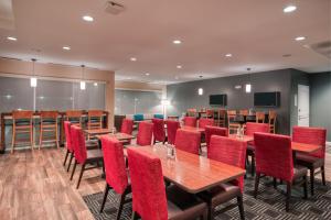 印第安纳波利斯TownePlace Suites by Marriott Indianapolis Airport的一间会议室,配有木桌和红色椅子