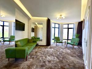 塔什干Garnet Hotel Tashkent的客厅配有绿色沙发和椅子