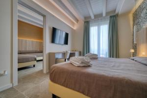 代森扎诺-德尔加达Hotel Palazzo del Garda & Spa的酒店客房,配有床和电视
