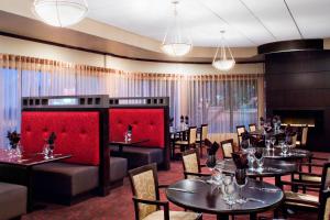 温尼伯南温尼伯喜来登福朋酒店的一间带桌椅和红色分隔的餐厅