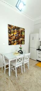 纳夫普利翁Didis Place Nafplio的厨房里配有白色的桌椅,墙上挂着一幅画