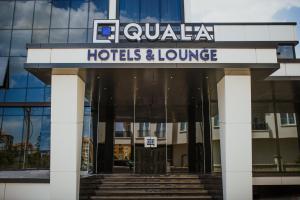 阿克萨赖QUALA HOTELS & LOUNGE的大楼前的酒店和休息室标志