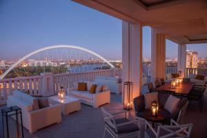 阿斯塔纳阿斯塔纳瑞吉酒店的阳台配有沙发和桌子,还有一座桥梁