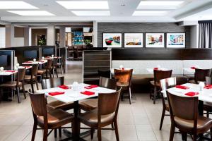 米西索加米西索加梅德维尔福朋喜来登酒店的餐厅配有桌椅和红色餐巾