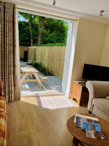 Sway3-bed cottage in Sway, New Forest (5 min walk from Sway Train Station)的客厅设有大型滑动玻璃门