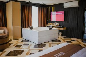 阿克萨赖QUALA HOTELS & LOUNGE的带浴缸的浴室和墙上的电视