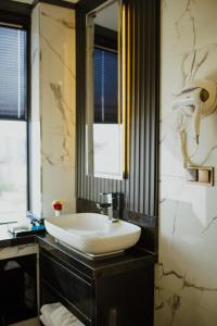 阿克萨赖QUALA HOTELS & LOUNGE的浴室设有白色水槽和镜子