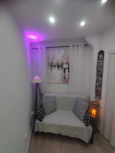塞萨洛尼基Paul's studios的客厅配有白色沙发和紫色灯