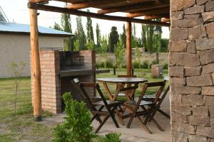 圣拉斐尔Cabañas Viento Andino的一个带桌椅和烧烤架的庭院