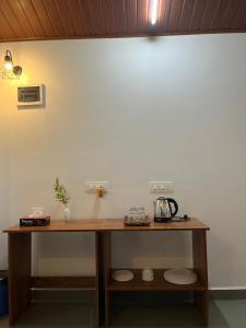 库斯哈尔纳加尔THE MASCARA - Home stay @ Coorg的白色墙壁上的木桌