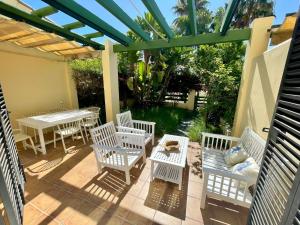 圣玛丽亚港GATU PREMIUM Villa Mar de Arabia的庭院配有白色的椅子、桌子和凉亭。