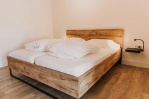 比伦Appartement Wadpier的一张带白色床单和枕头的木床