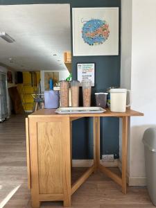 纽基Blue Room Hostel Newquay的一张木桌,上面有杯子