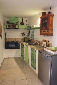 基奥尼亚Castria studios的厨房配有绿色和白色的橱柜和洗碗机。