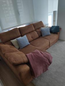 希洪Precioso apartamento recién reformado的客厅配有带枕头的棕色沙发