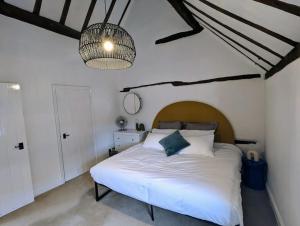 布由德利Zeppelin House - Riverside 18th Century Townhouse的卧室配有一张白色大床和吊灯。
