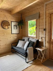 比迪福德Log Cabin的木制客房内的沙发,设有窗户