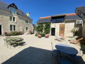 HuismesLogement Loire climatisé, La Halte de Cuze, aux abords de la Loire a vélo的一个带桌椅的庭院和一座建筑