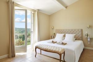 圣特罗佩Golf Resort & Country Club Saint-Tropez的一间卧室设有一张大床和大窗户