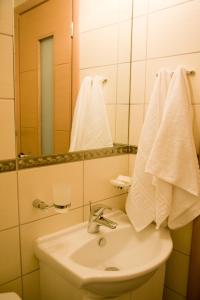 托隆Onira Boutique的浴室配有盥洗盆、镜子和毛巾
