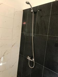 拉脱维亚Viesu nams Baņuta1的浴室铺有黑白瓷砖,设有淋浴。