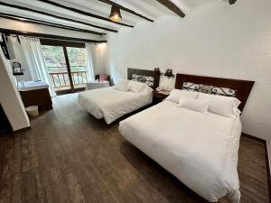 马丘比丘Hatun Inti Boutique的酒店客房设有两张床和窗户。