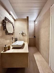 马尔马里Marmari Paradise Resort Hotel的一间带水槽和镜子的浴室