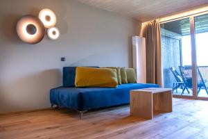 韦尔图尔诺Vinumhotel Feldthurnerhof的客厅配有蓝色的沙发和桌子
