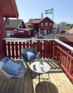 卡琳贡Hotell Käringön的阳台上的木制甲板上配有桌椅