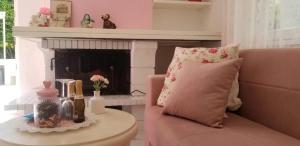 拉韦诺-蒙贝洛ViLLETTA CLAUDETTA的客厅配有粉红色的沙发和壁炉