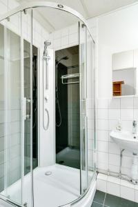 厄勒布鲁Hotell Hof的一个带水槽的玻璃淋浴间