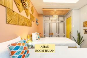 马尼拉Rain Airport Bed and Breakfast的一间设有两张床的房间和一个阅读了亚洲人的标志