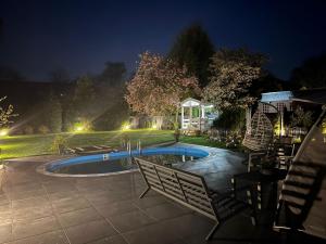 居特斯洛LUXUS-RelaxDays-Apartments的夜间在院子里的游泳池